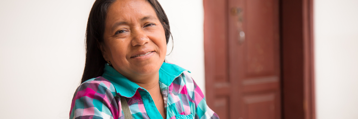 Image shows a woman looking at the camera and smiling